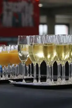 Elegant array of champagne and orange juice glasses at an indoor event, ready for celebration. corporate party diakosmisi 2